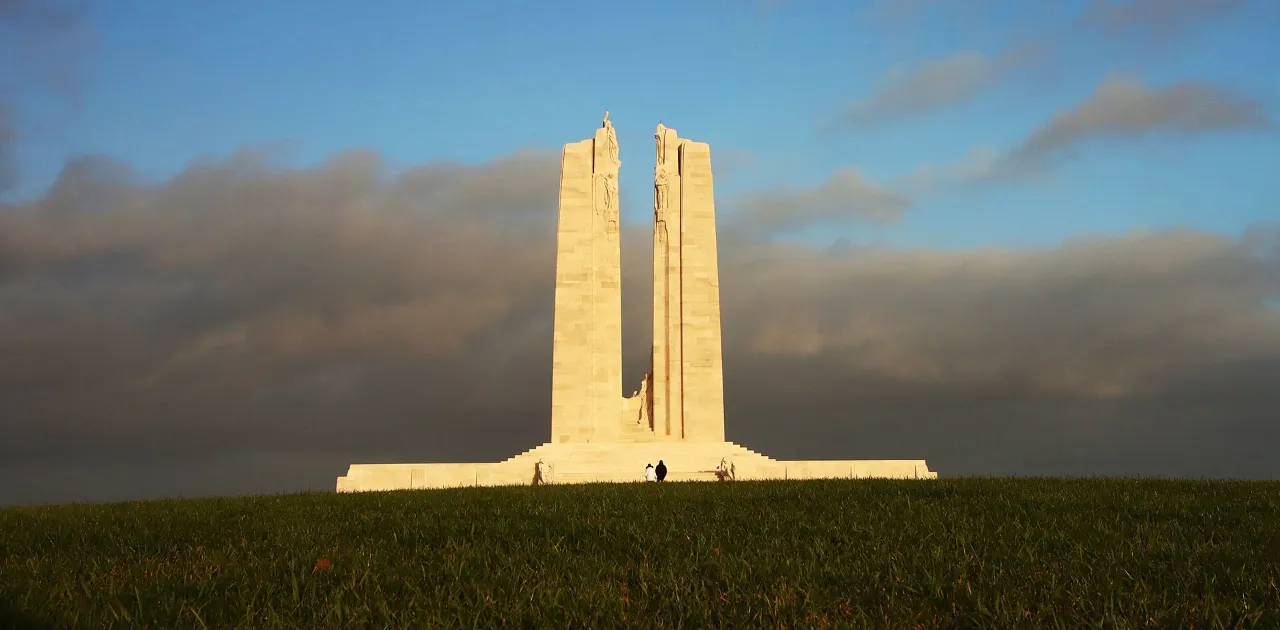 Les deux pylônes blancs du Mémorial canadien de Vimy éclairés par le soleil au bout d’une prairie
